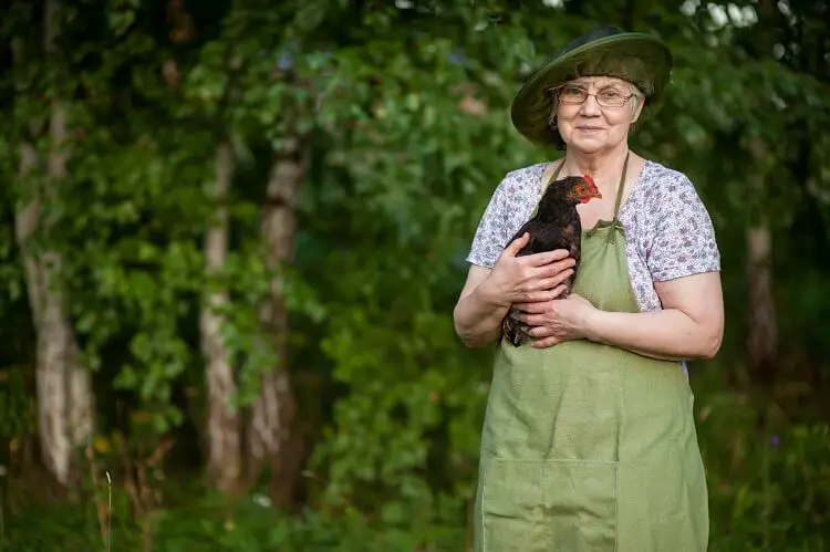 mujer sosteniendo un pollo