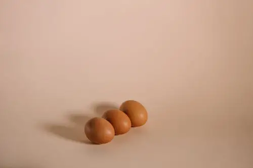 Tres huevos marrones en superficie blanca